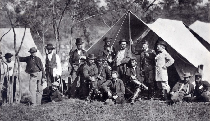 Photograph shows fourteen men, including Allan and William Pinkerton, and several Union Army officers posed in front of a tent.